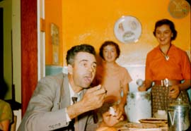 1957_UncleHerb_eating_pie_Ramona_Mary_watching